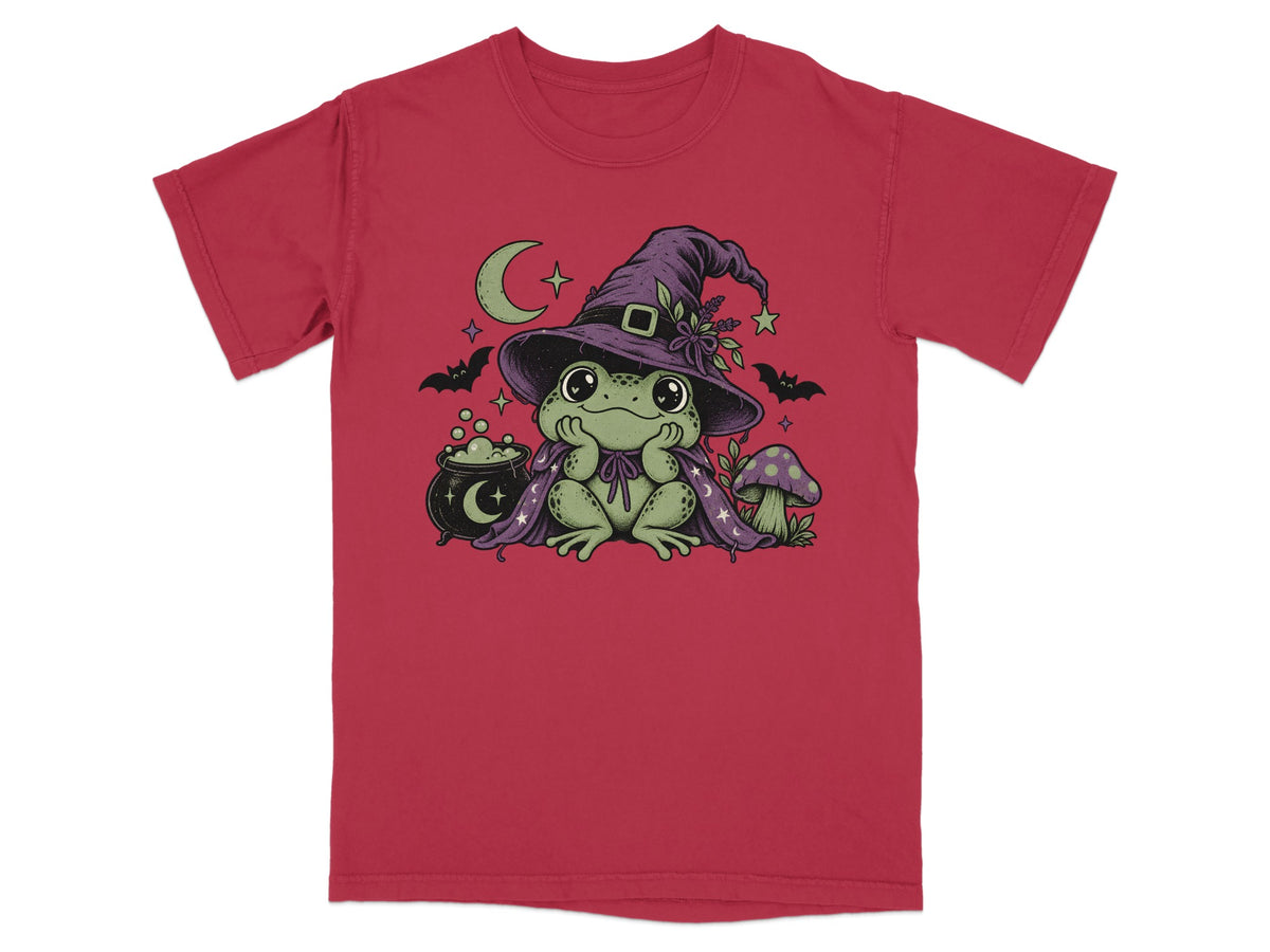 Red short-sleeve t-shirt featuring a graphic of a green frog wearing a witch hat and cape.