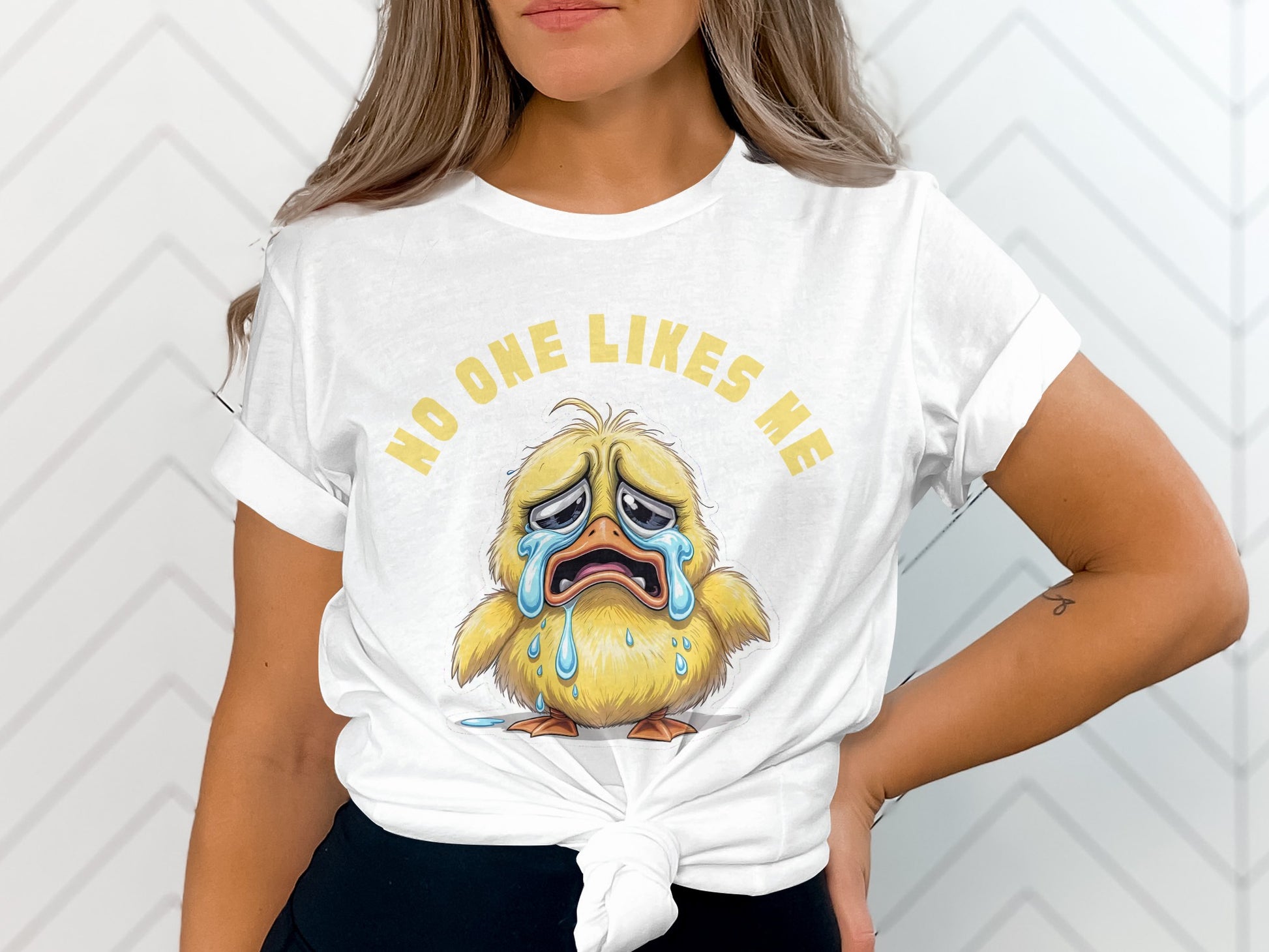 White t-shirt with crying duck graphic and text "NO ONE LIKES ME."