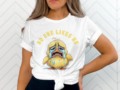 White t-shirt with crying duck graphic and text "NO ONE LIKES ME."
