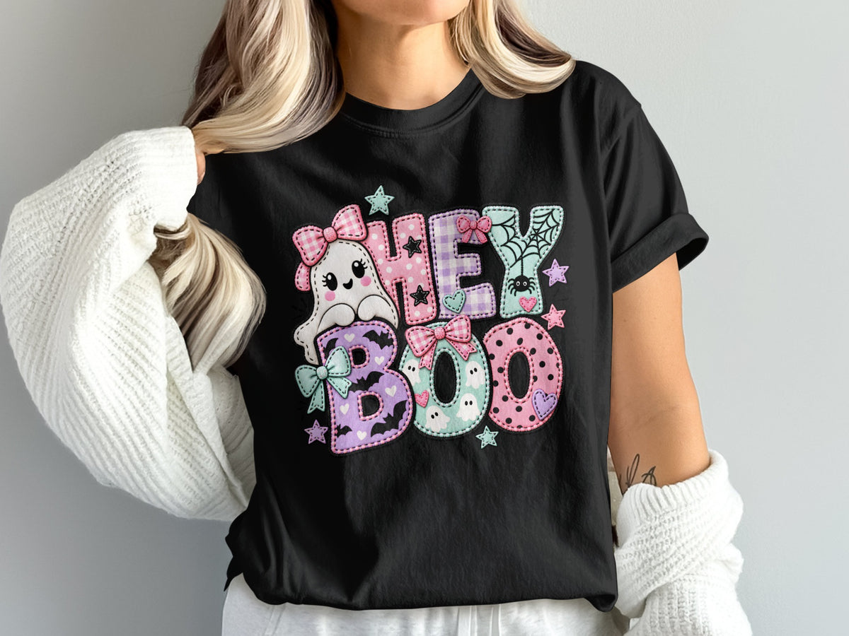 Black t-shirt with "HEY BOO" text and cute ghost, spider, and stars in pastel patchwork style.