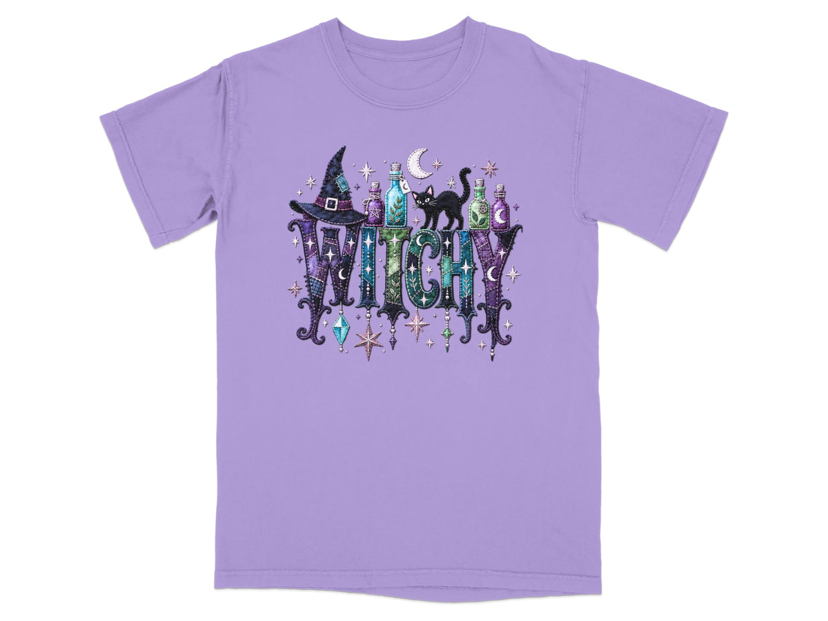 Purple t-shirt with a witch hat, potions, black cat, and "WITCHY" text.