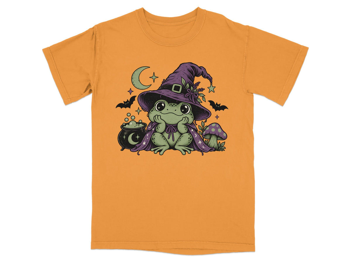 An orange t-shirt featuring a graphic of a green frog wearing a witch hat and cape.