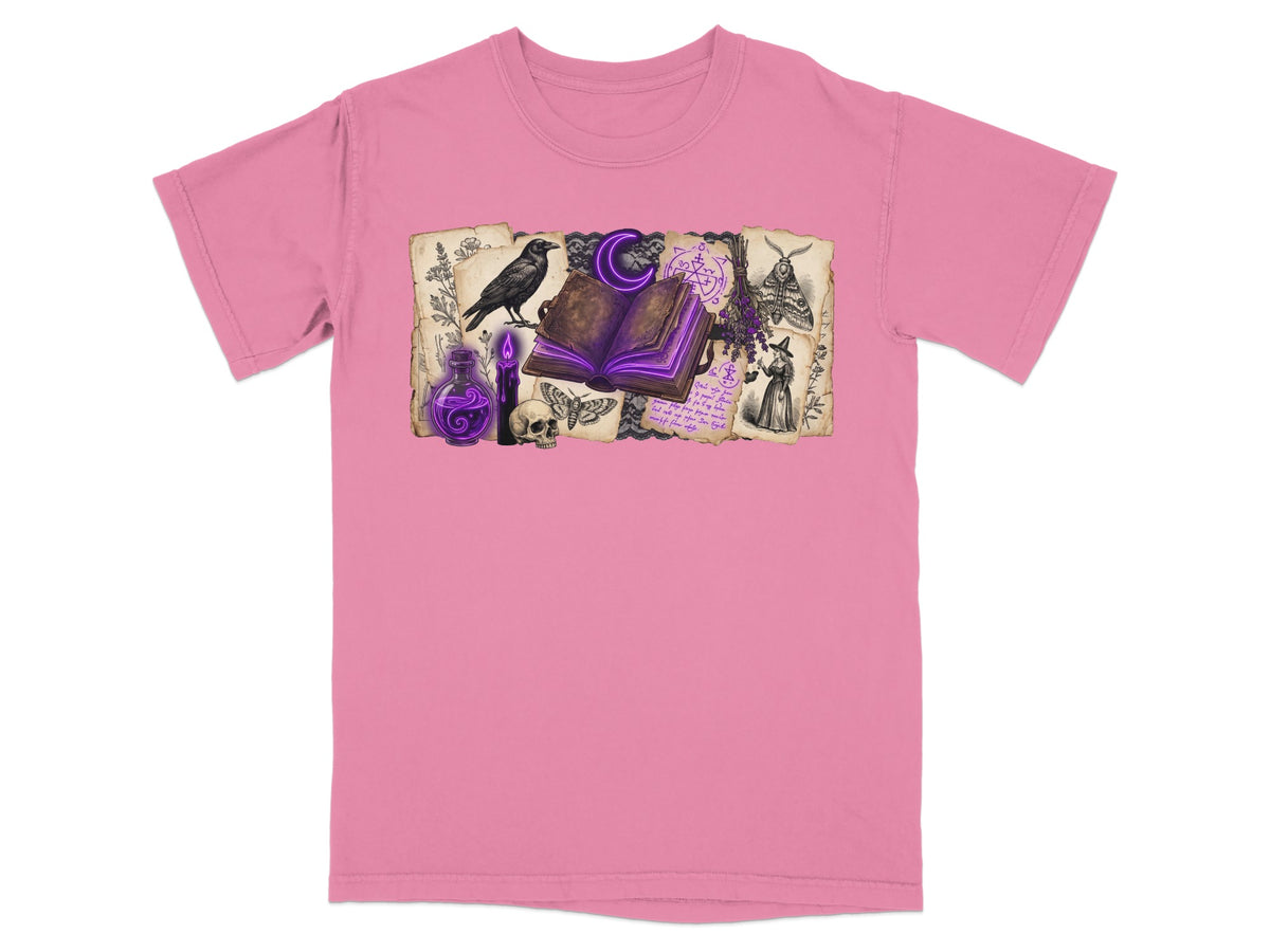 Pink t-shirt with an occult-themed graphic featuring a raven, open book, and potions.