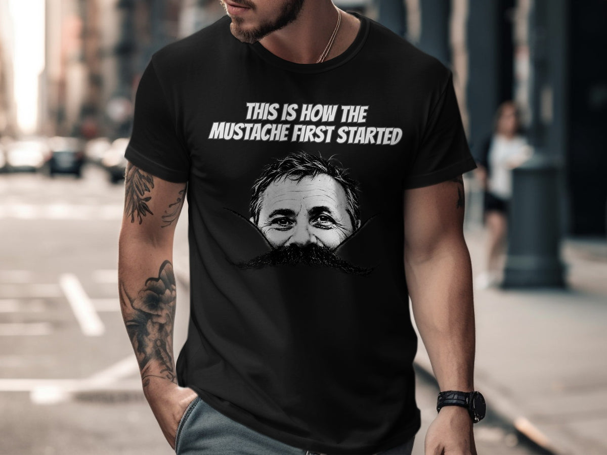 Black t-shirt with text "THIS IS HOW THE MUSTACHE FIRST STARTED" and a man's face with mustache.