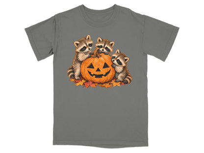 Three raccoons surround a jack-o'-lantern with autumn leaves.