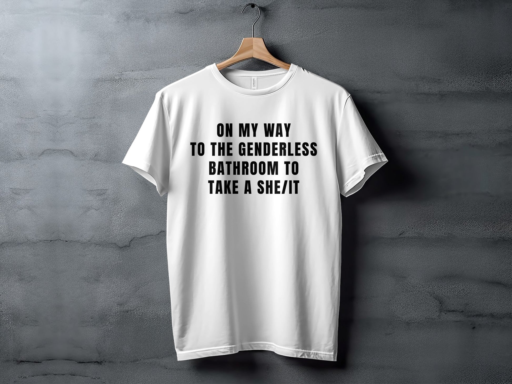 White t-shirt with black text: "On my way to the genderless bathroom to take a she/it."