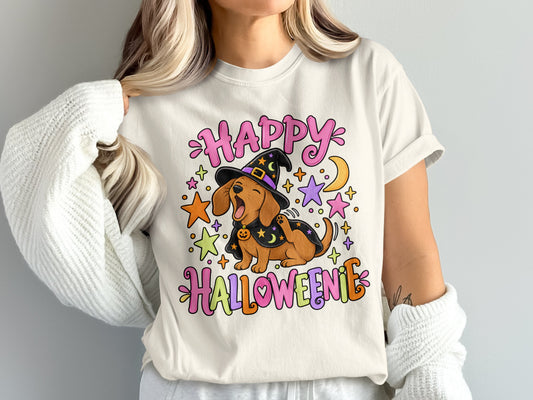 Happy Halloweenie text with cartoon dachshund wearing witch hat and cape.