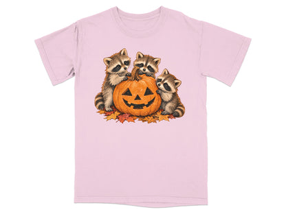Three raccoons surround a jack-o'-lantern on a bed of autumn leaves.