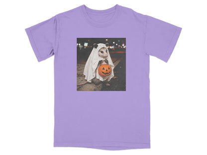 Opossum in ghost costume holding a jack-o-lantern bucket on a street at night.