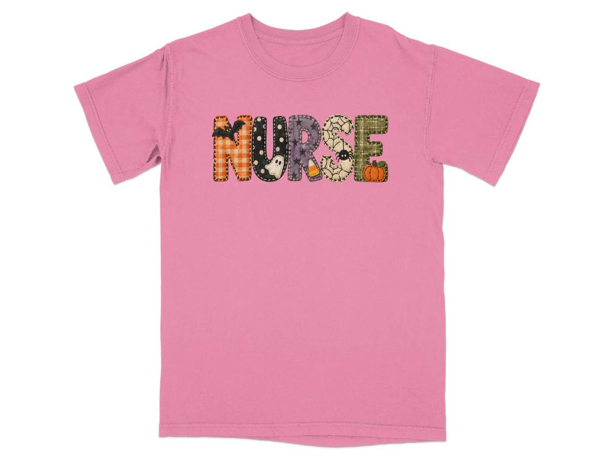 A pink short-sleeved t-shirt featuring the word NURSE in patterned Halloween-themed block letters across the chest.