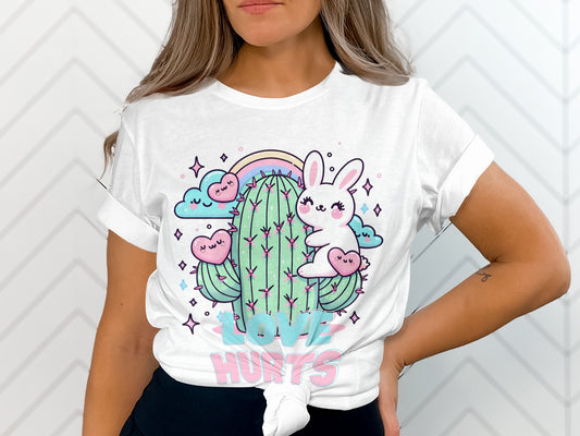 White t-shirt featuring a cute bunny and cactus illustration with text "Love Hurts."