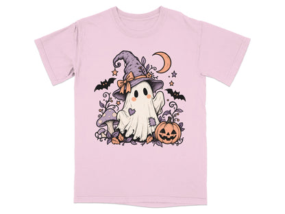 A light pink t-shirt featuring an illustration of a cute ghost wearing a witch hat, surrounded by bats, pumpkins, and mushrooms.