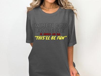 Gray t-shirt with text: "WHEN GOD MADE ME HE GRINNED AND SAID 'THIS'LL BE FUN'"