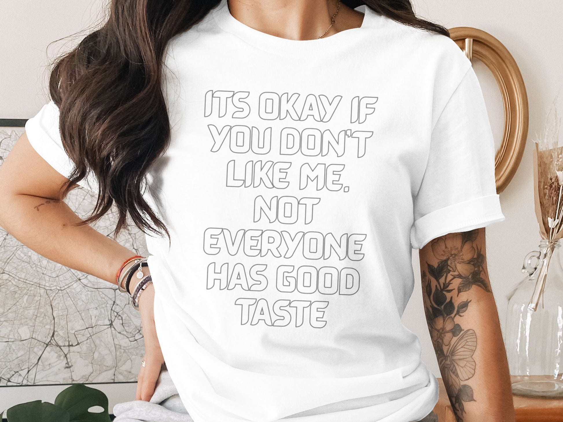 White t-shirt with gray text "IT'S OKAY IF YOU DON'T LIKE ME, NOT EVERYONE HAS GOOD TASTE".