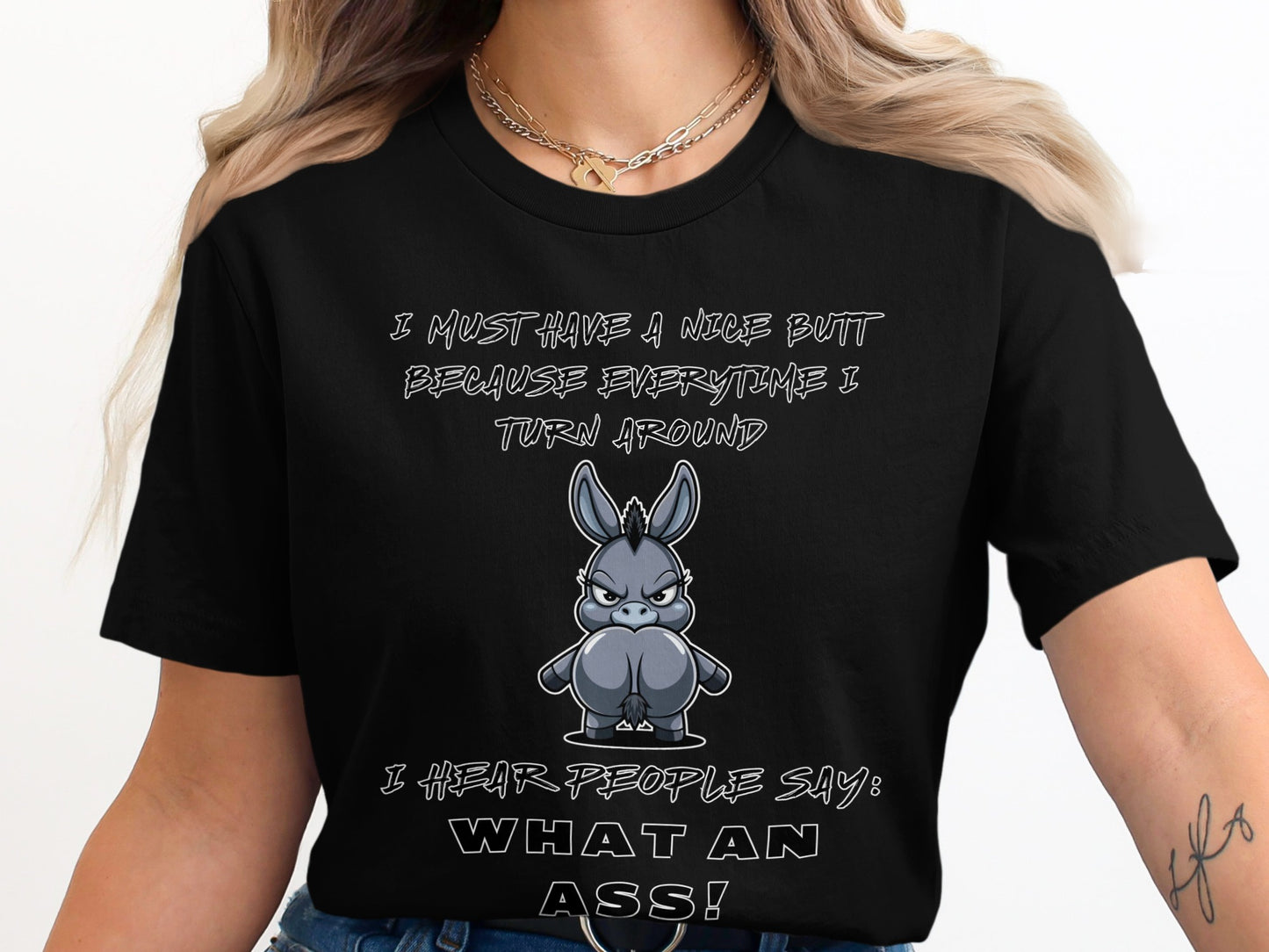 Black t-shirt with cartoon donkey and text: "I MUST HAVE A NICE BUTT BECAUSE EVERYTIME I TURN AROUND I HEAR PEOPLE SAY: WHAT AN ASS!"