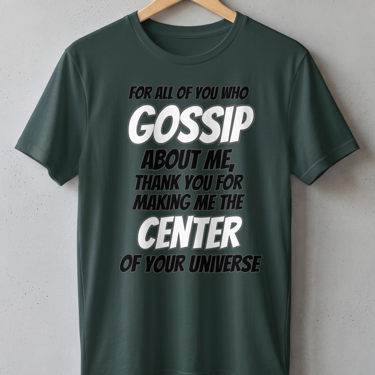 Dark green t-shirt with text "GOSSIP ABOUT ME, THANK YOU FOR MAKING ME THE CENTER OF YOUR UNIVERSE".