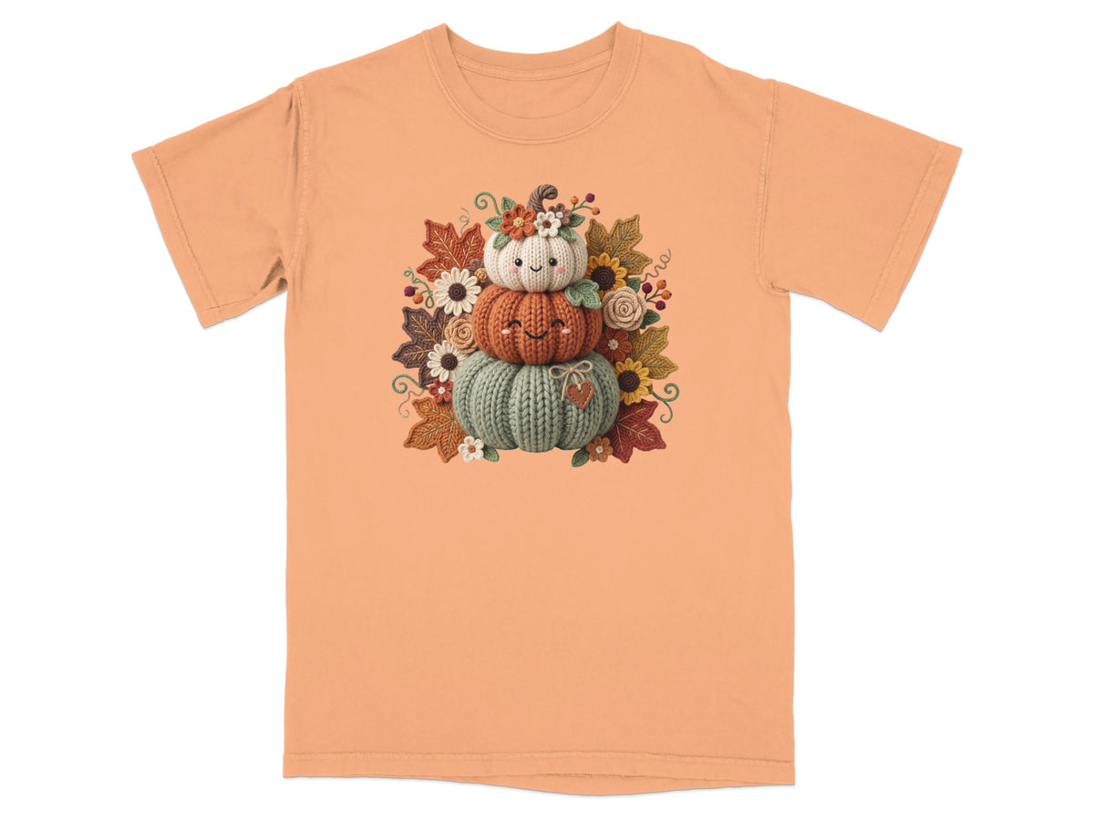 Orange t-shirt with a stacked pumpkin design and fall leaves and flowers.