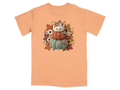 Orange t-shirt with a stacked pumpkin design and fall leaves and flowers.