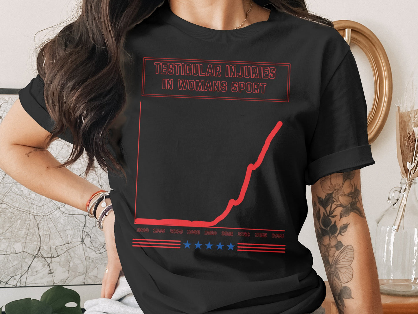 Black t-shirt with text "Testicular Injuries in Woman's Sport" and a rising graph.