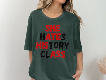 Dark green t-shirt with "SHE HATES HISTORY CLASS" in red and black text.