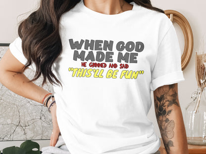 White t-shirt with text "When God Made Me He Grinned And Said 'This'll Be Fun'".