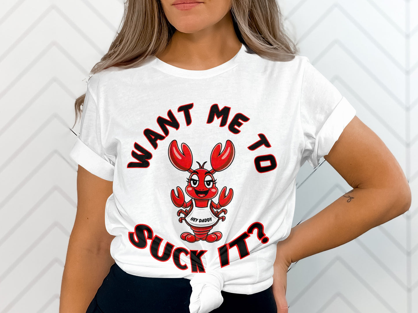 White t-shirt featuring a cartoon lobster and text "WANT ME TO SUCK IT?".