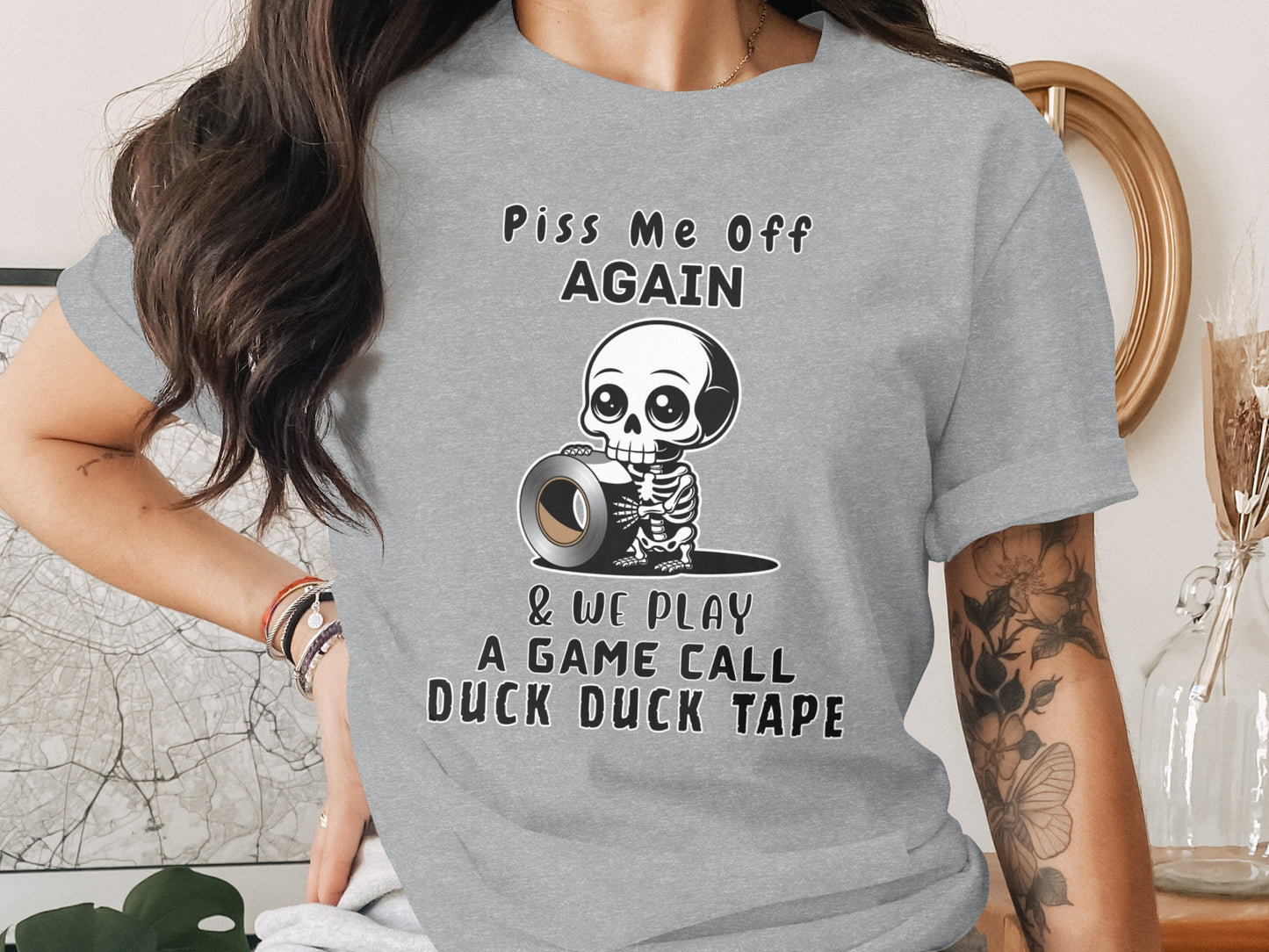 Gray t-shirt with skeleton holding duct tape and text "Piss Me Off Again & We Play A Game Call Duck Duck Tape".