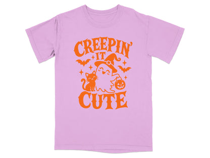 Pink t-shirt with orange Halloween graphic: "Creepin' It Cute" with ghost, cat, bats, and pumpkin.