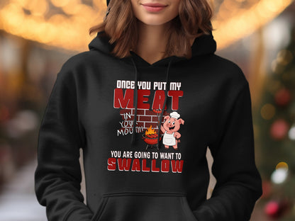 Black hoodie with a cartoon pig chef and text about grilling meat.