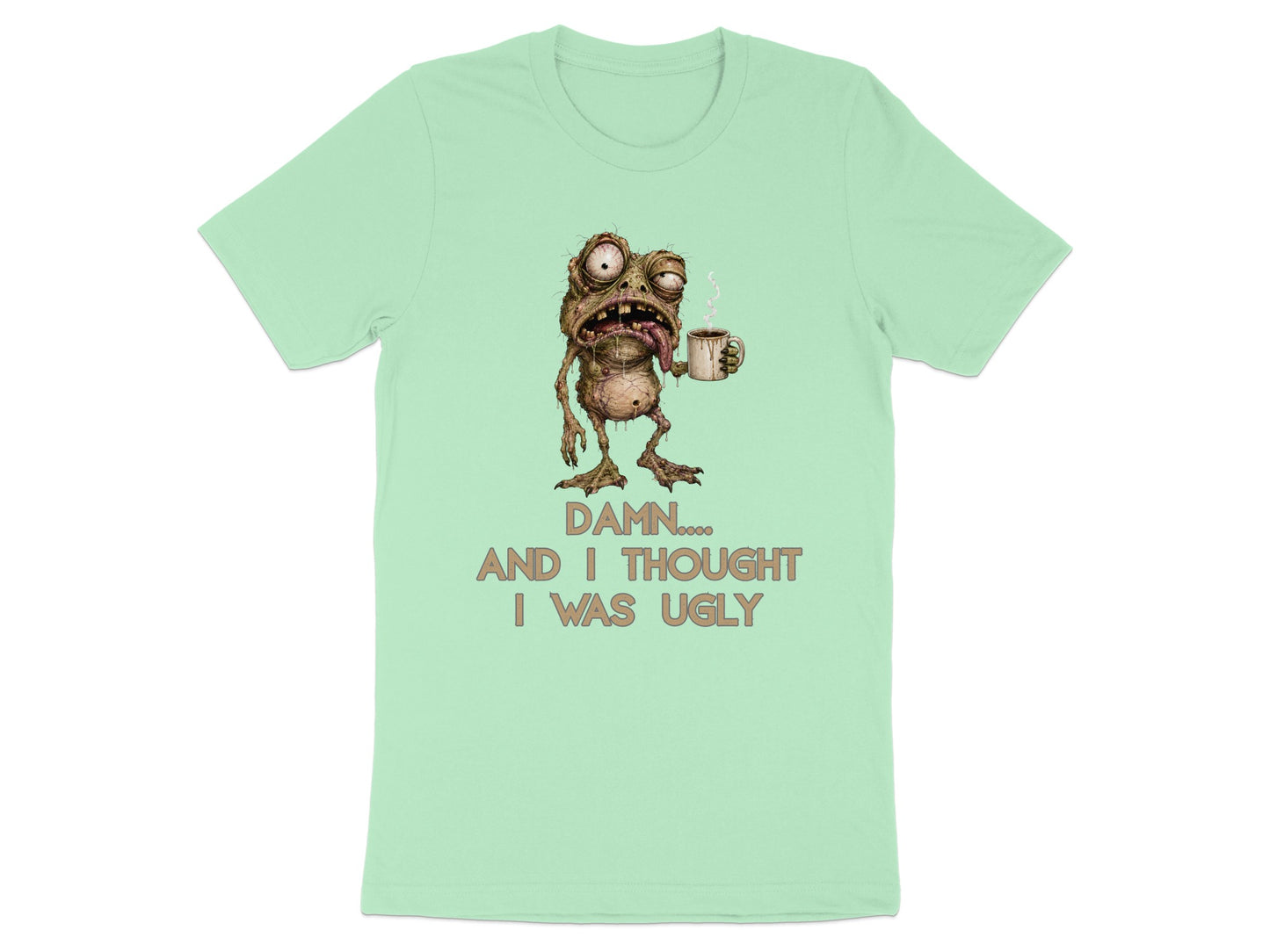 Mint t-shirt with a grotesque creature holding coffee and text that reads "DAMN.... AND I THOUGHT I WAS UGLY".