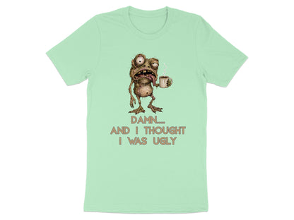 Mint t-shirt with a grotesque creature holding coffee and text that reads "DAMN.... AND I THOUGHT I WAS UGLY".