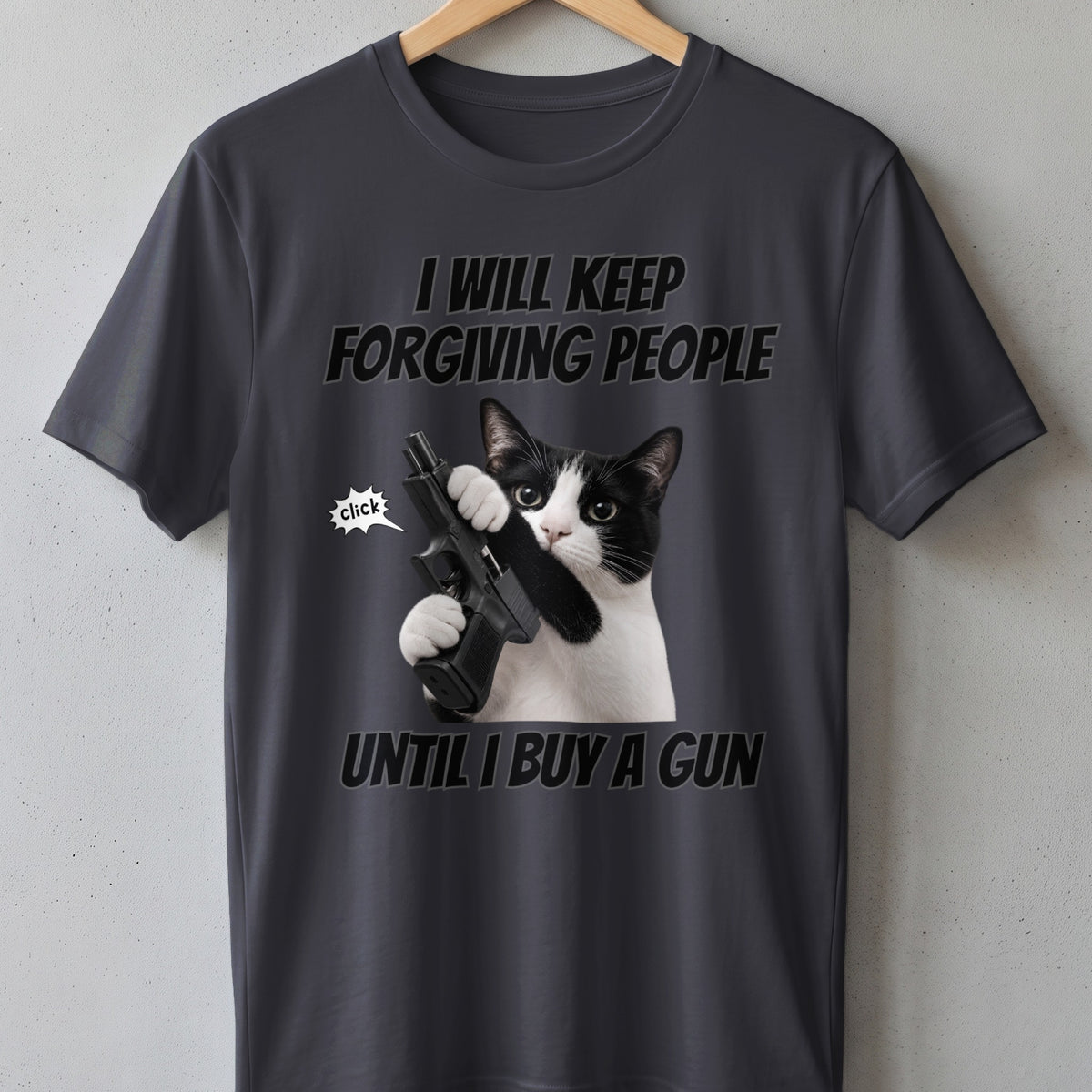T-shirt with a black and white cat holding a gun and the text "I will keep forgiving people until I buy a gun."