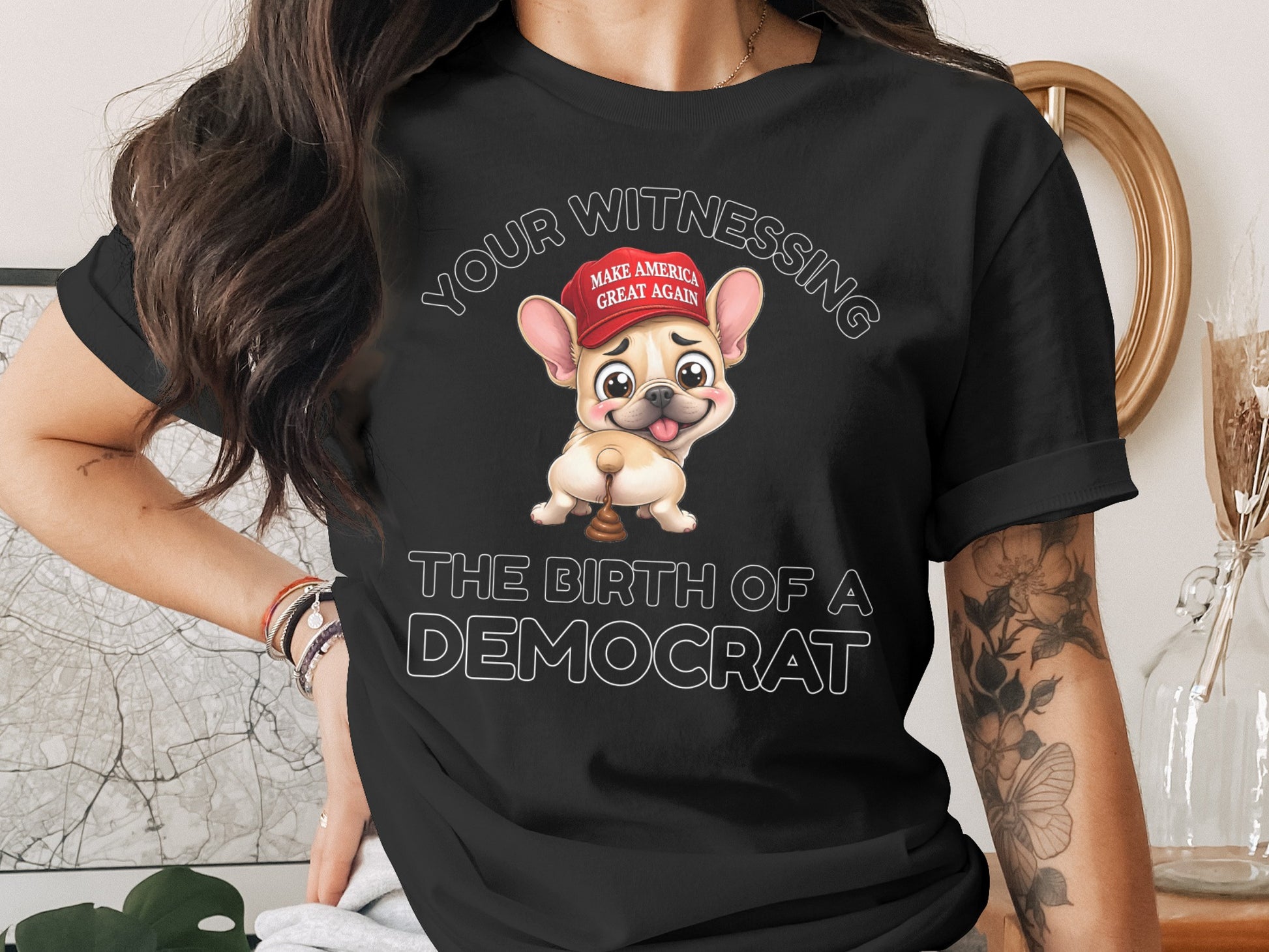 Black t-shirt with cartoon French bulldog wearing "Make America Great Again" hat, text: The Birth of a Democrat