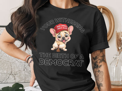 Black t-shirt with cartoon French bulldog wearing "Make America Great Again" hat, text: The Birth of a Democrat