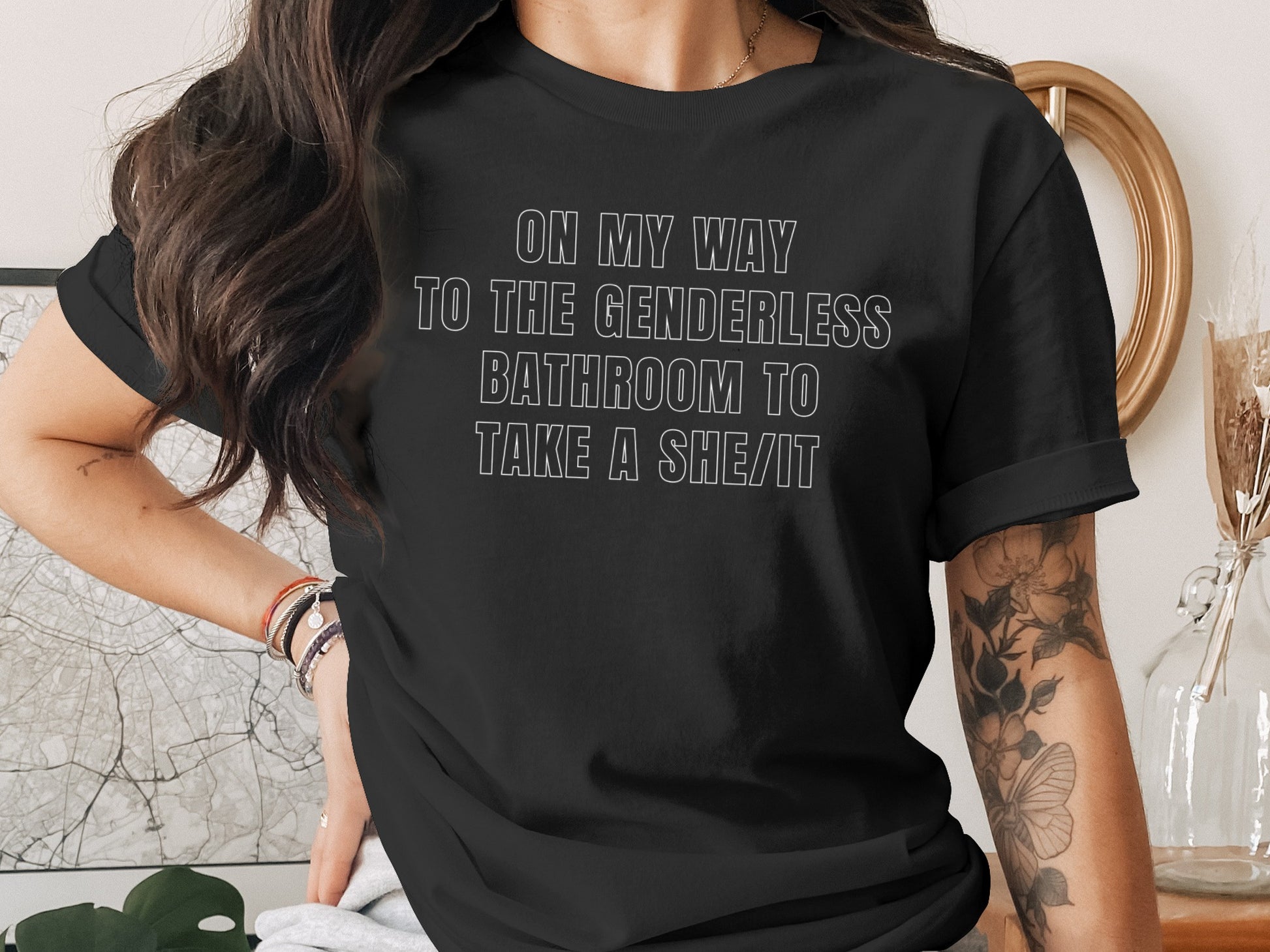 Black t-shirt with white text "On my way to the genderless bathroom to take a she/it".