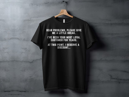Black t-shirt with white text: "Dear problems, please give me a little break. I've been your most loyal customer for years. At this point, I deserve a discount..."