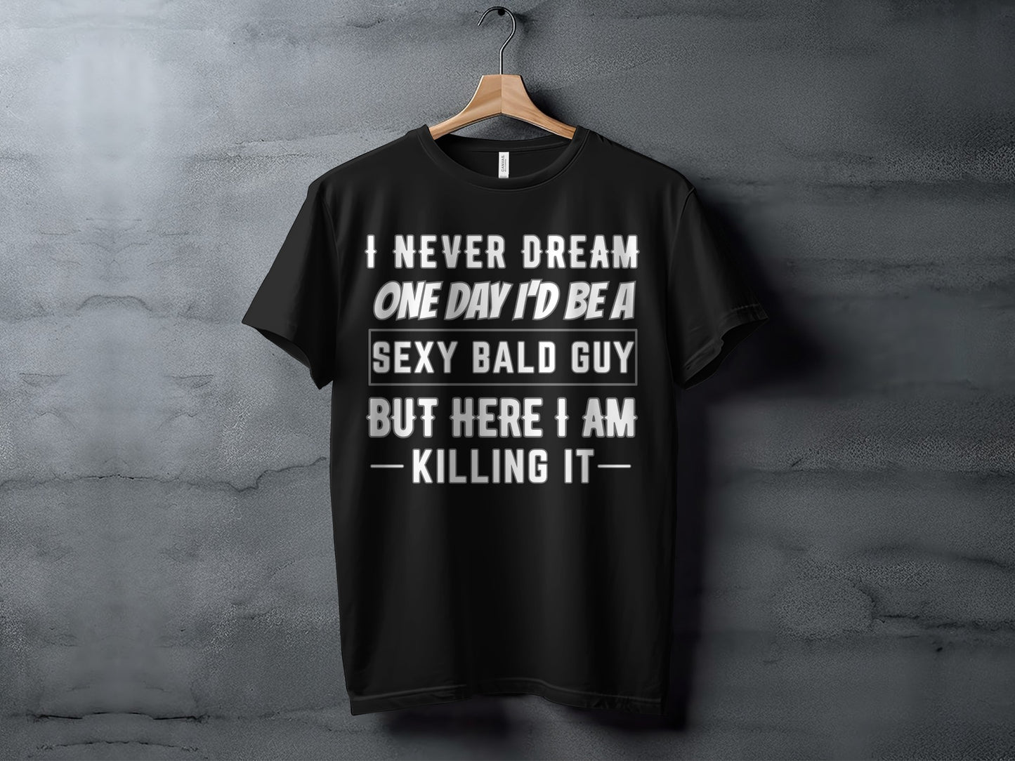 Black t-shirt with text: "I never dream one day I'd be a sexy bald guy but here I am - killing it."