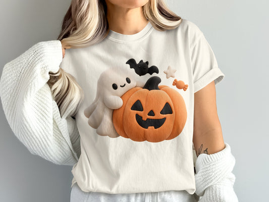 White t-shirt with a cute ghost, jack-o'-lantern, bat, stars, and candy graphic.