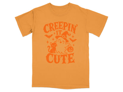 Orange t-shirt with "Creepin' It Cute" Halloween graphic featuring a ghost and cat.