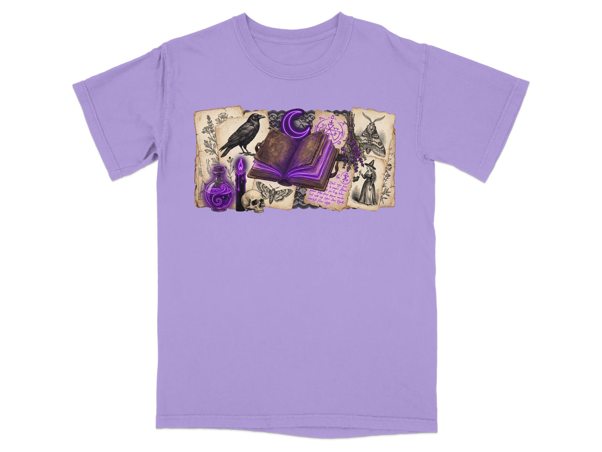 Purple t-shirt with gothic illustration of crow, book, potion, skull, moths, and witch.