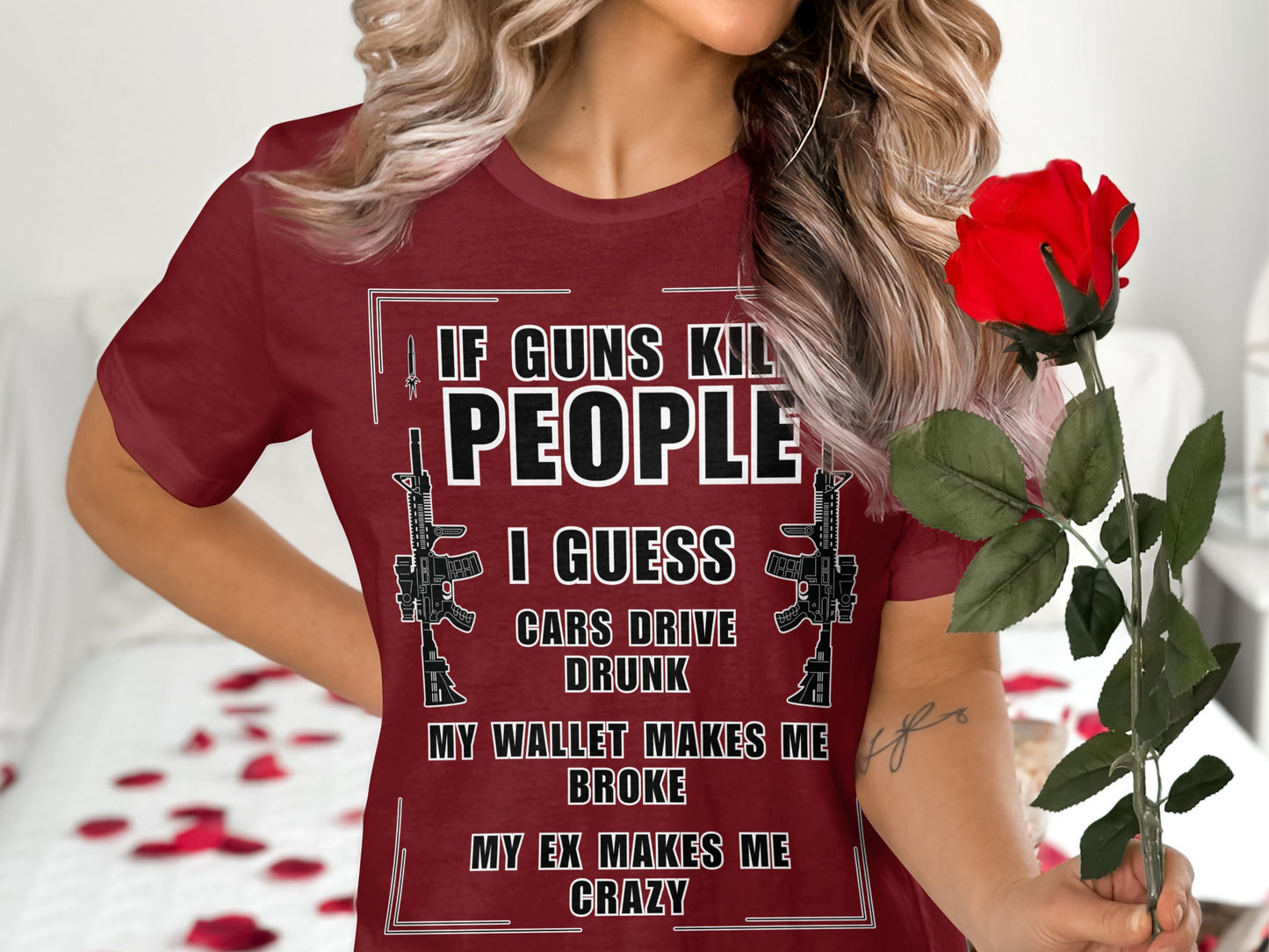T-shirt with "If guns kill people" text and gun graphics, held by a person with a rose.