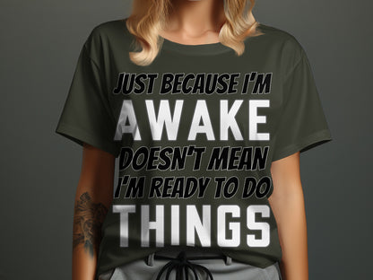 Dark green t-shirt with "JUST BECAUSE I'M AWAKE DOESN'T MEAN I'M READY TO DO THINGS" text.