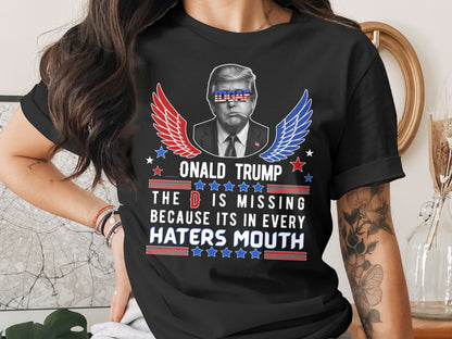 Black t-shirt with Donald Trump graphic and text: "The D is missing because it's in every haters mouth."