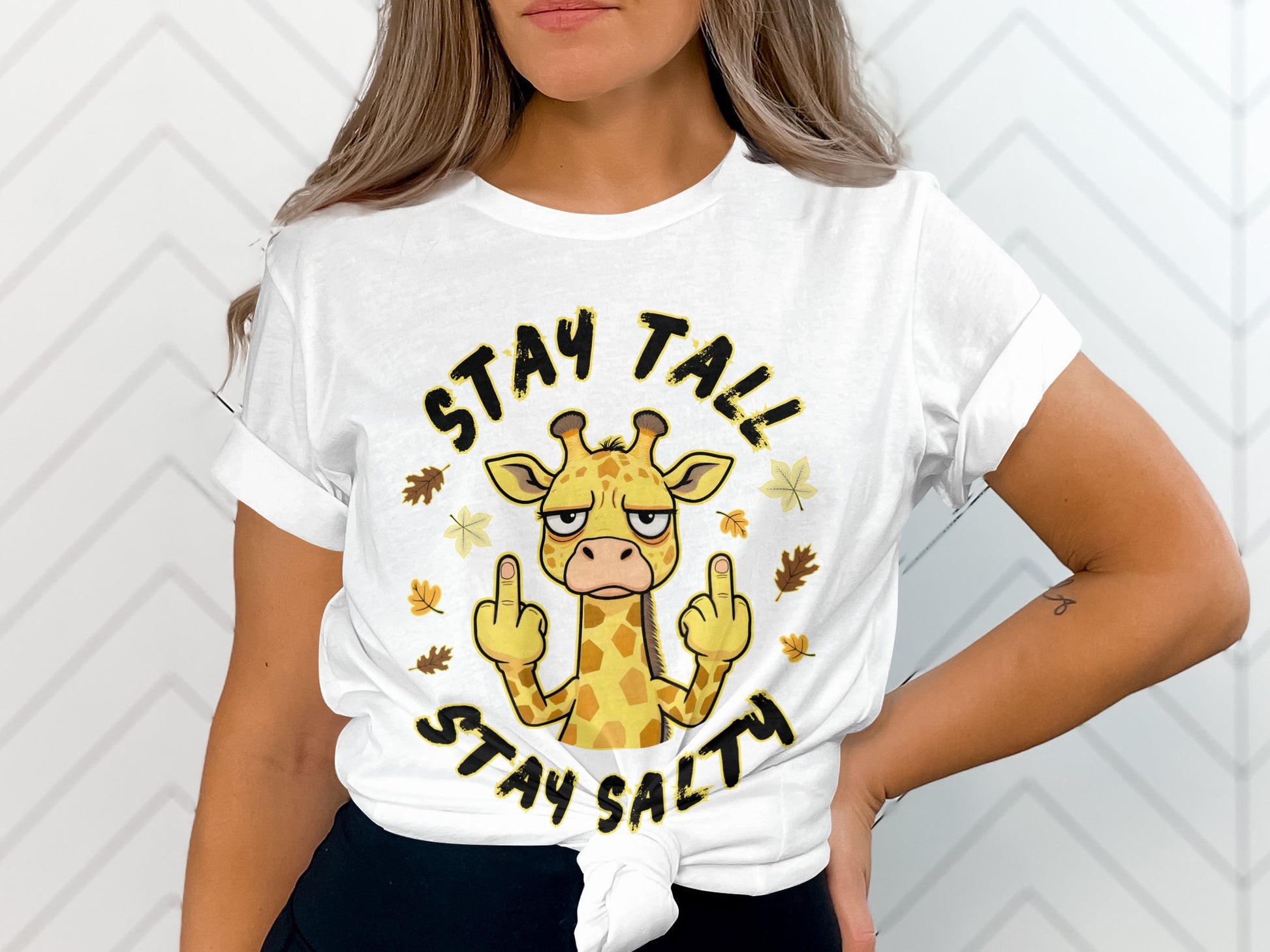 White t-shirt with a cartoon giraffe giving the middle finger, text reads "Stay Tall Stay Salty".