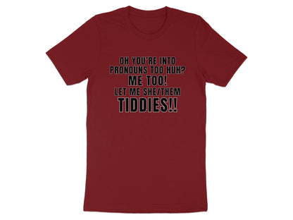 Burgundy t-shirt with text: "Oh you're into pronouns too huh? Me too! Let me she/them tiddies!!"