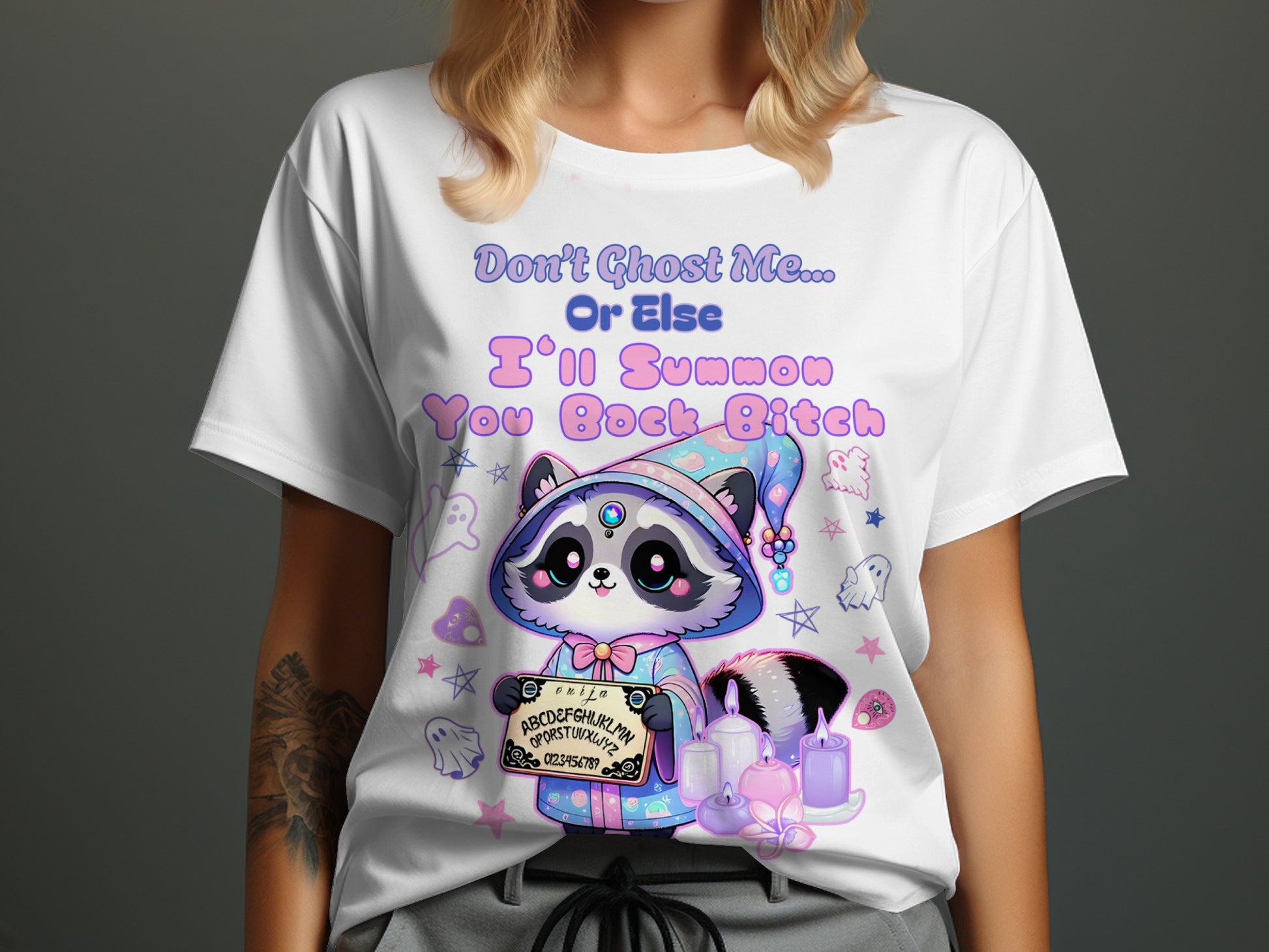 White t-shirt with raccoon in wizard hat holding Ouija board and candles.