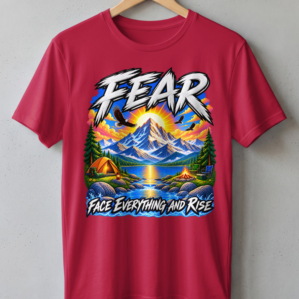 T-shirt graphic with mountains, lake, tent, campfire, eagles, and text "FEAR FACE EVERYTHING AND RISE".