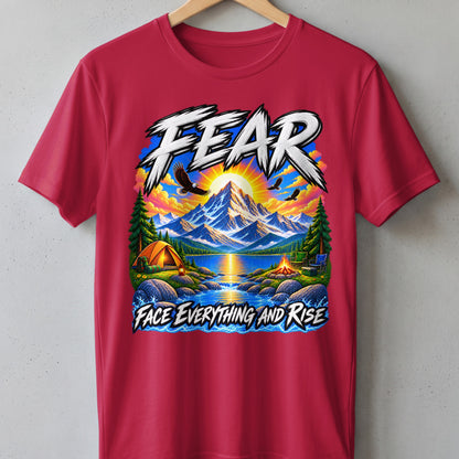 T-shirt graphic with mountains, lake, tent, campfire, eagles, and text "FEAR FACE EVERYTHING AND RISE".