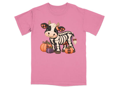 Skeleton cow with pumpkins and plaid accents on a pink t-shirt.