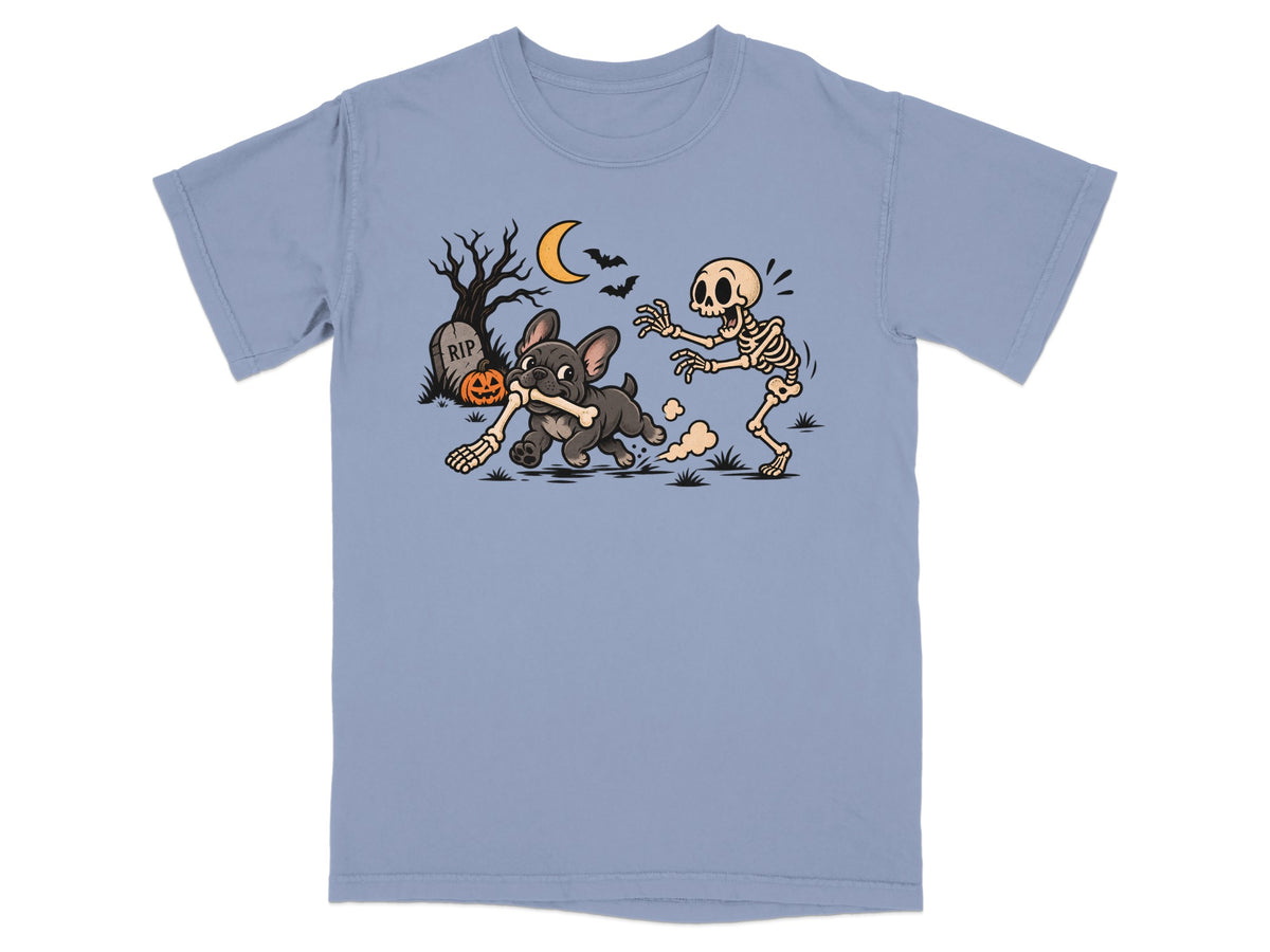 French bulldog runs with a bone while a skeleton chases it near a tombstone.